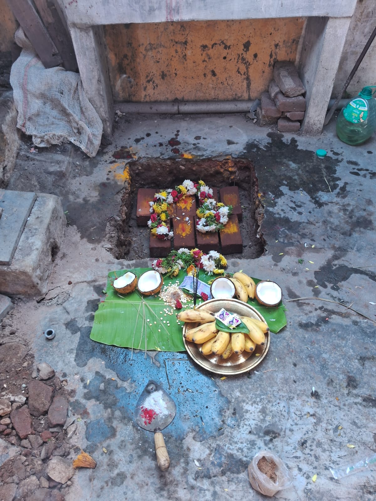 Priest standing beside the restoration area during bhoomi pooja